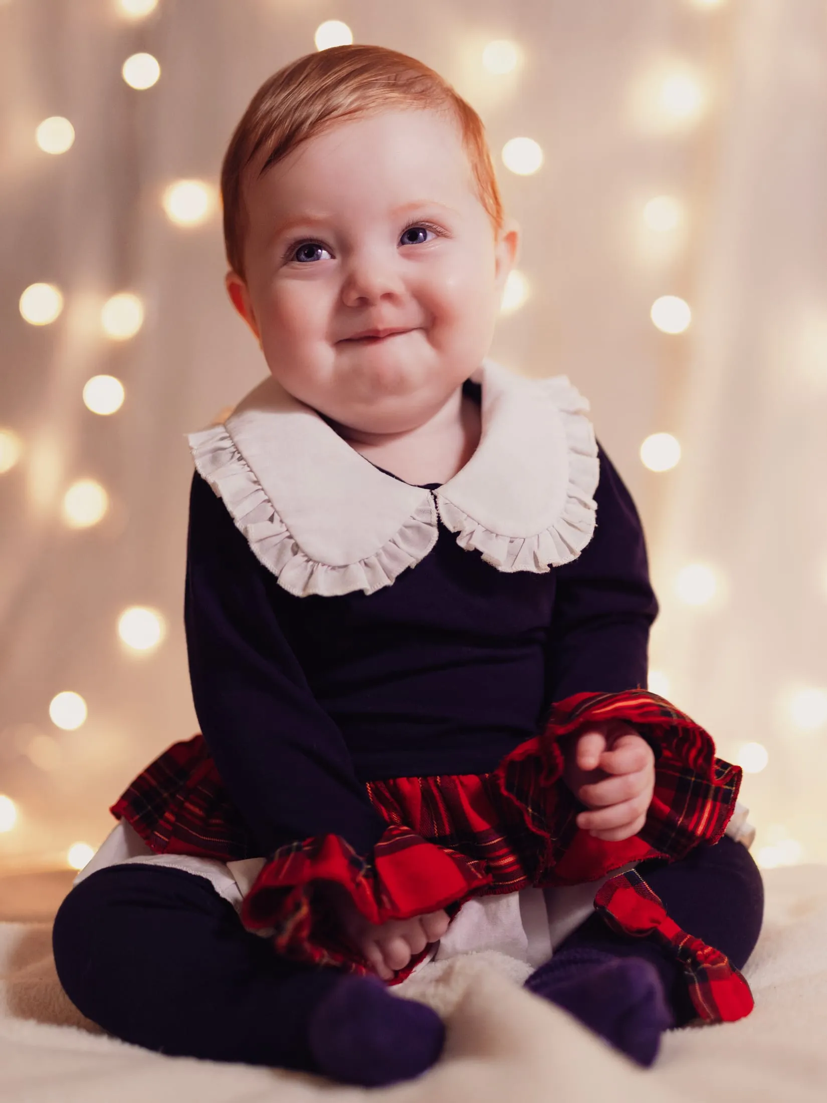 Young child in a frilled collar against soft festive light