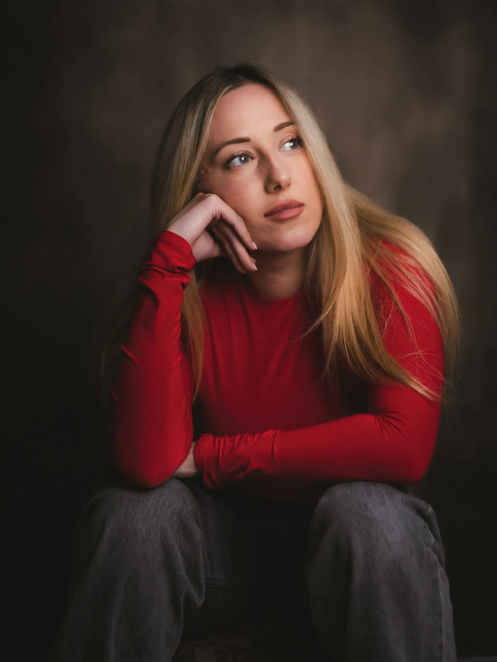 Portrait of a woman in red against a dark backdrop