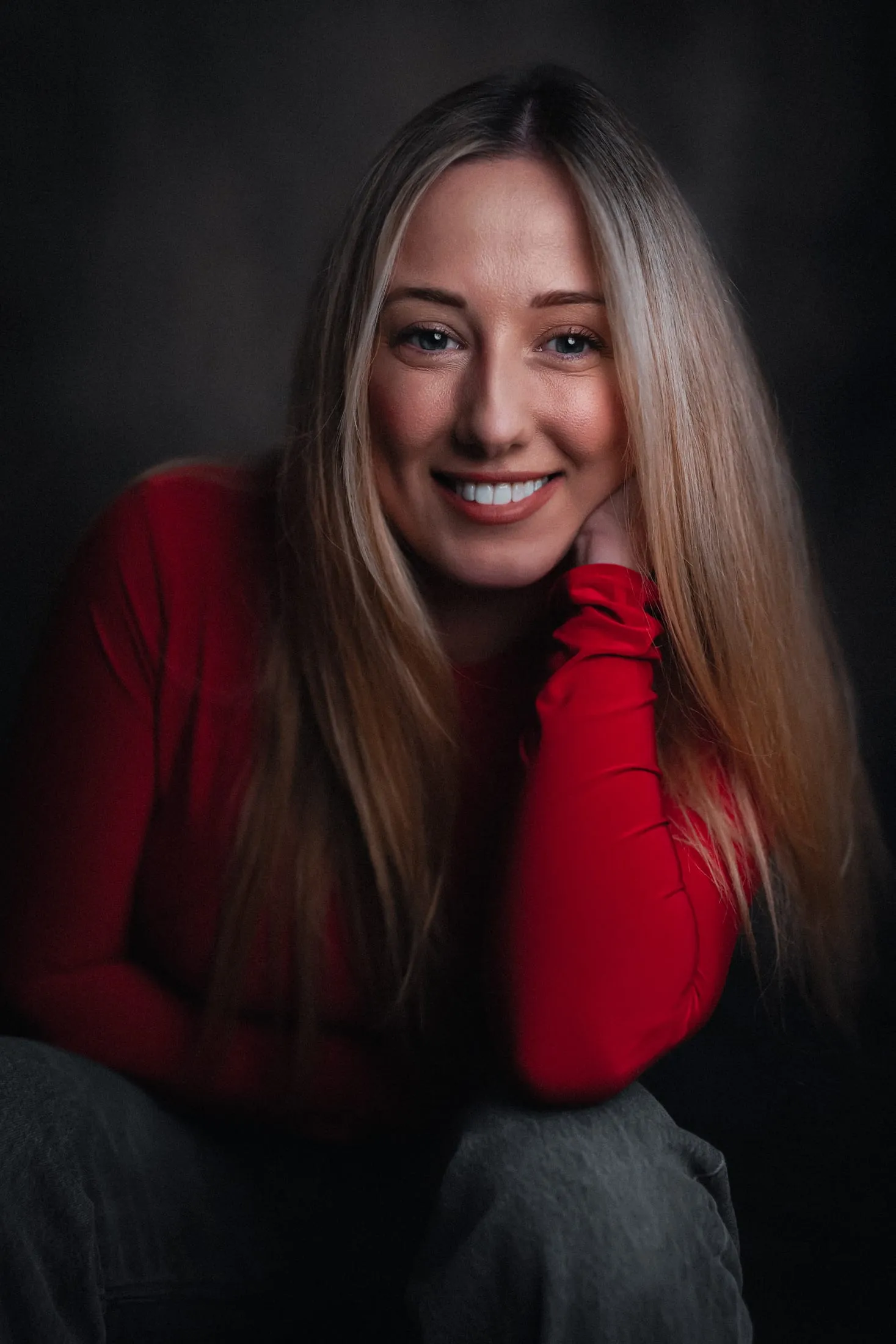 Low-light studio portrait of a woman in red