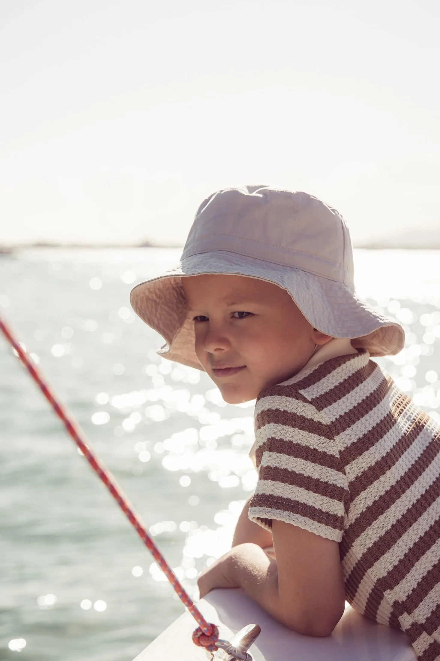 Child in a sun hat beside the water