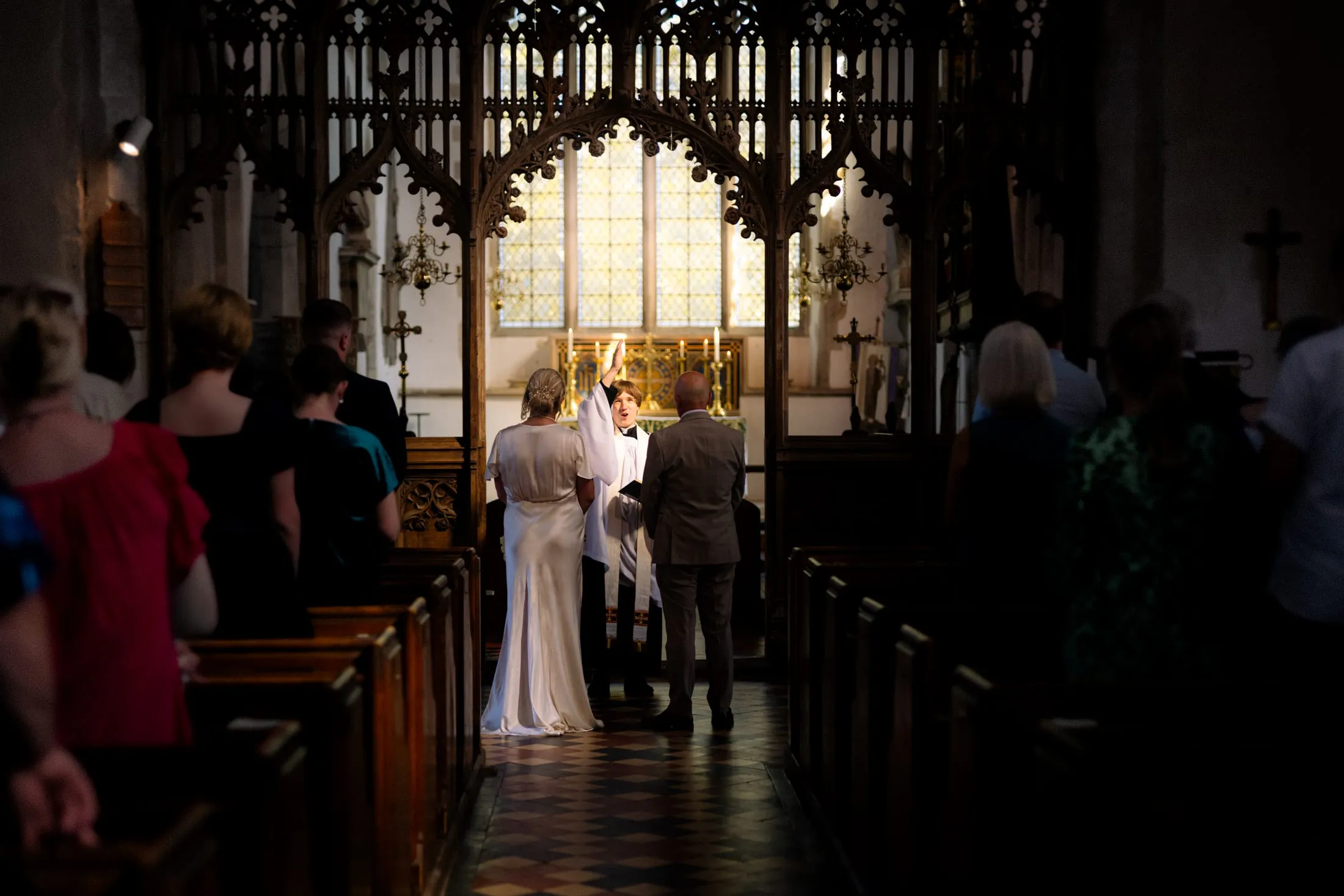 Bride and groom at the altar during the ceremony in a candlelit church