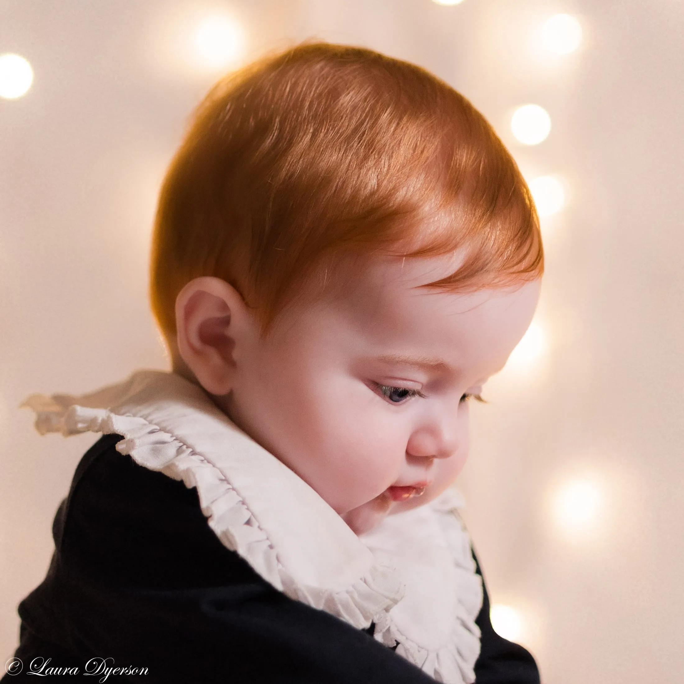 Red-haired baby in a frilled collar